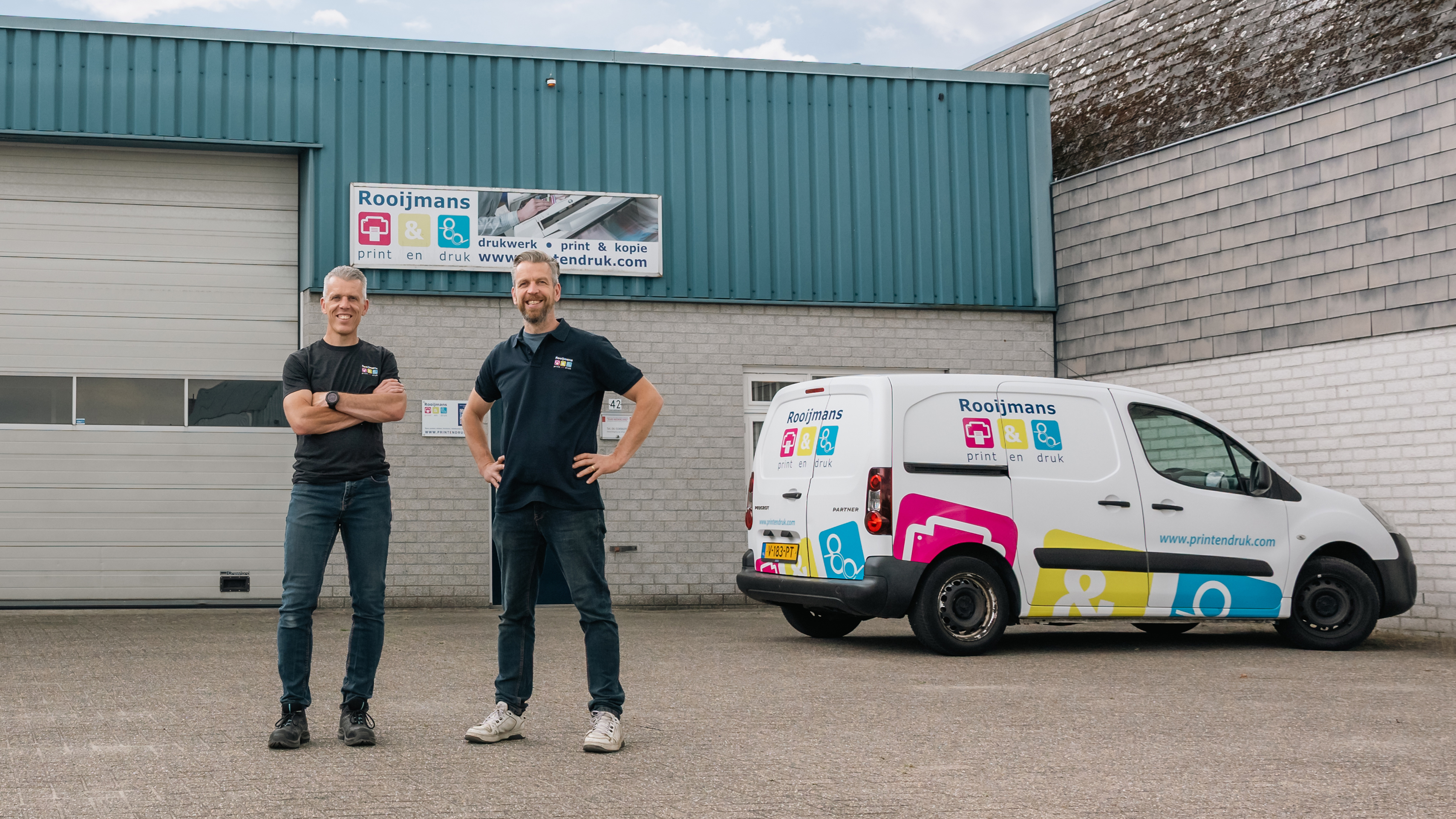 Sander en Gerard Rooijmans voor het pand van Rooijmans Print en Druk in Nuenen